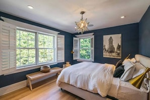 Ein Schlafzimmer mit einem großen Bett, einer Bank und einer deckenhohen Lampe in Sternform.