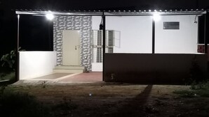 Ein zweistöckiges Gebäude mit einer Ziegel-Fassade und einem weißen Obergeschoss.