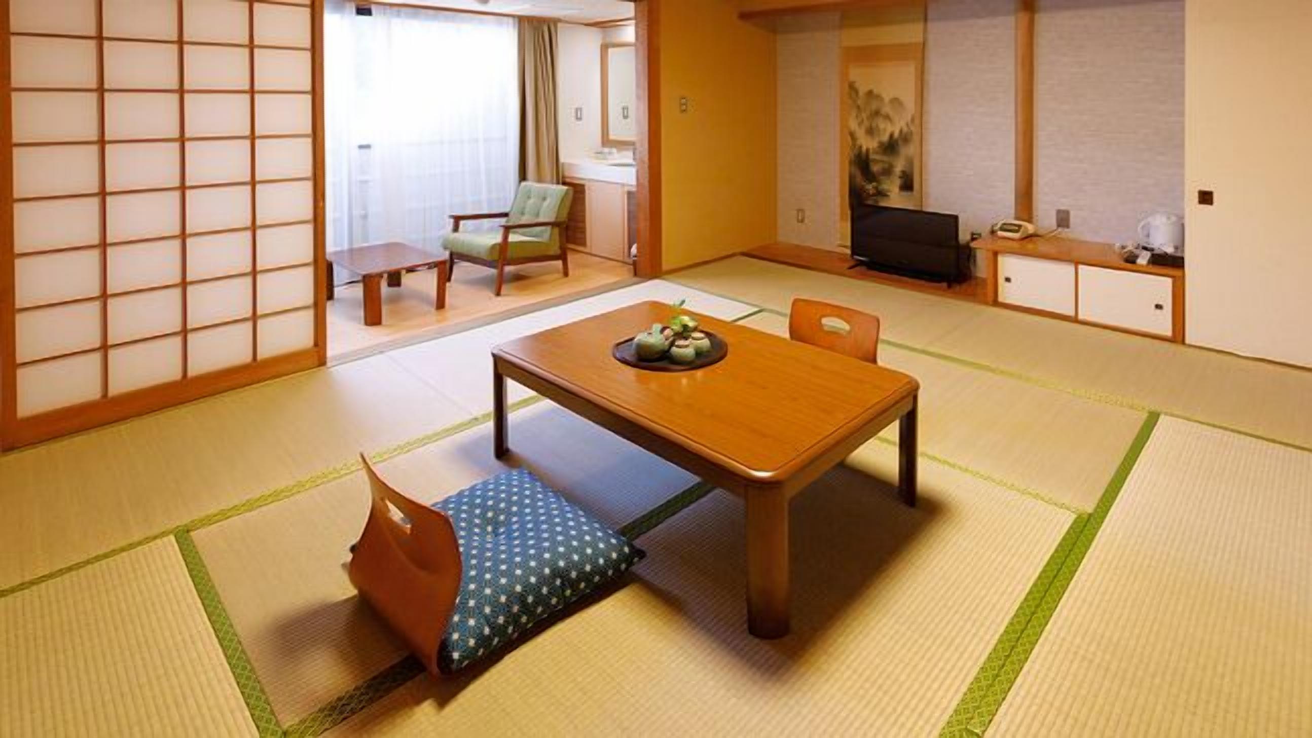 A traditional Japanese room with tatami flooring, a low table with a small dish, and a television.