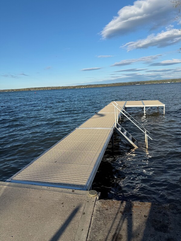 Un muelle de madera que se adentra en un cuerpo de agua, con un cielo despejado.