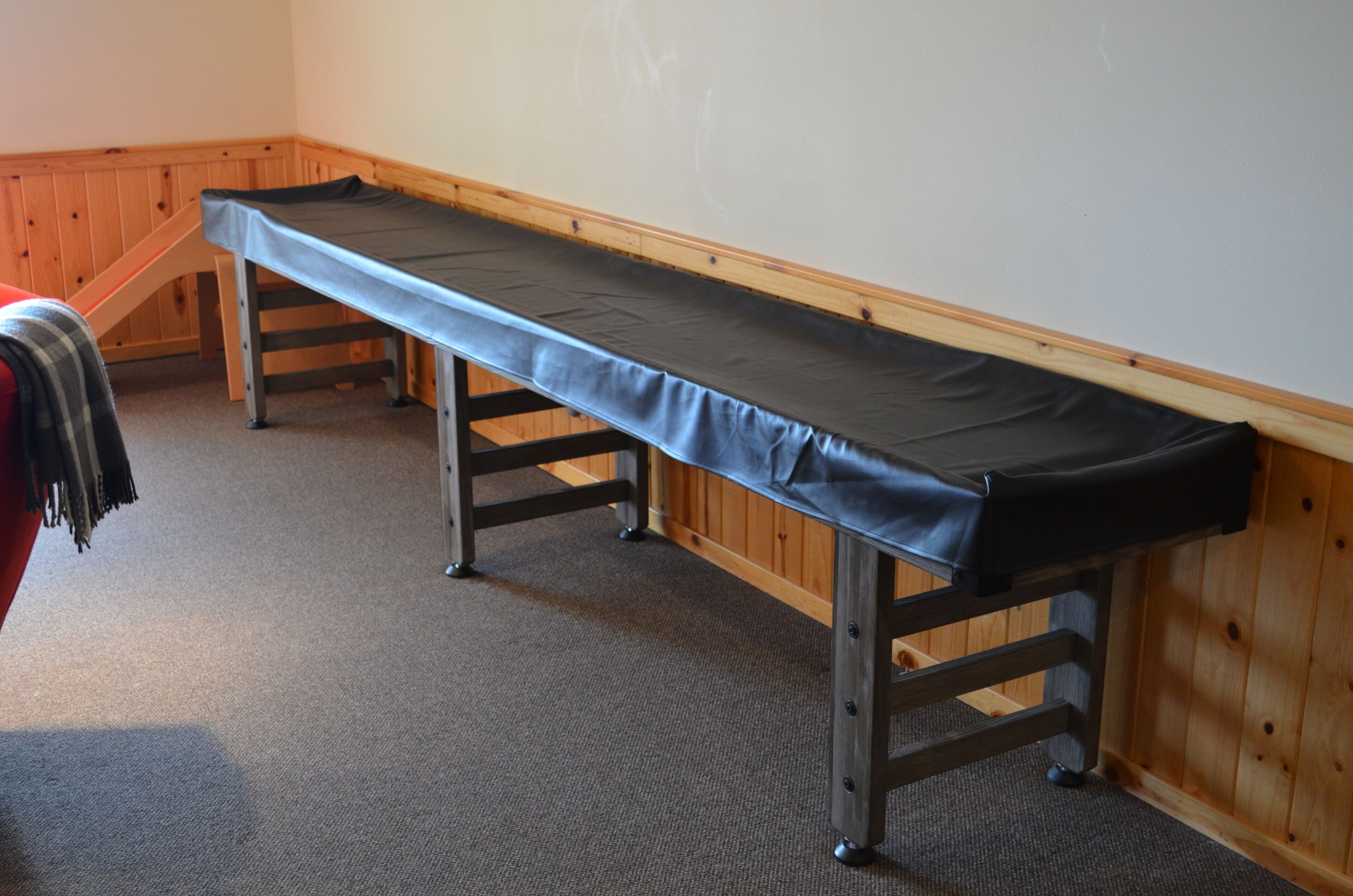 Ein Zimmer mit einer hölzernen Bank und Teppichboden.