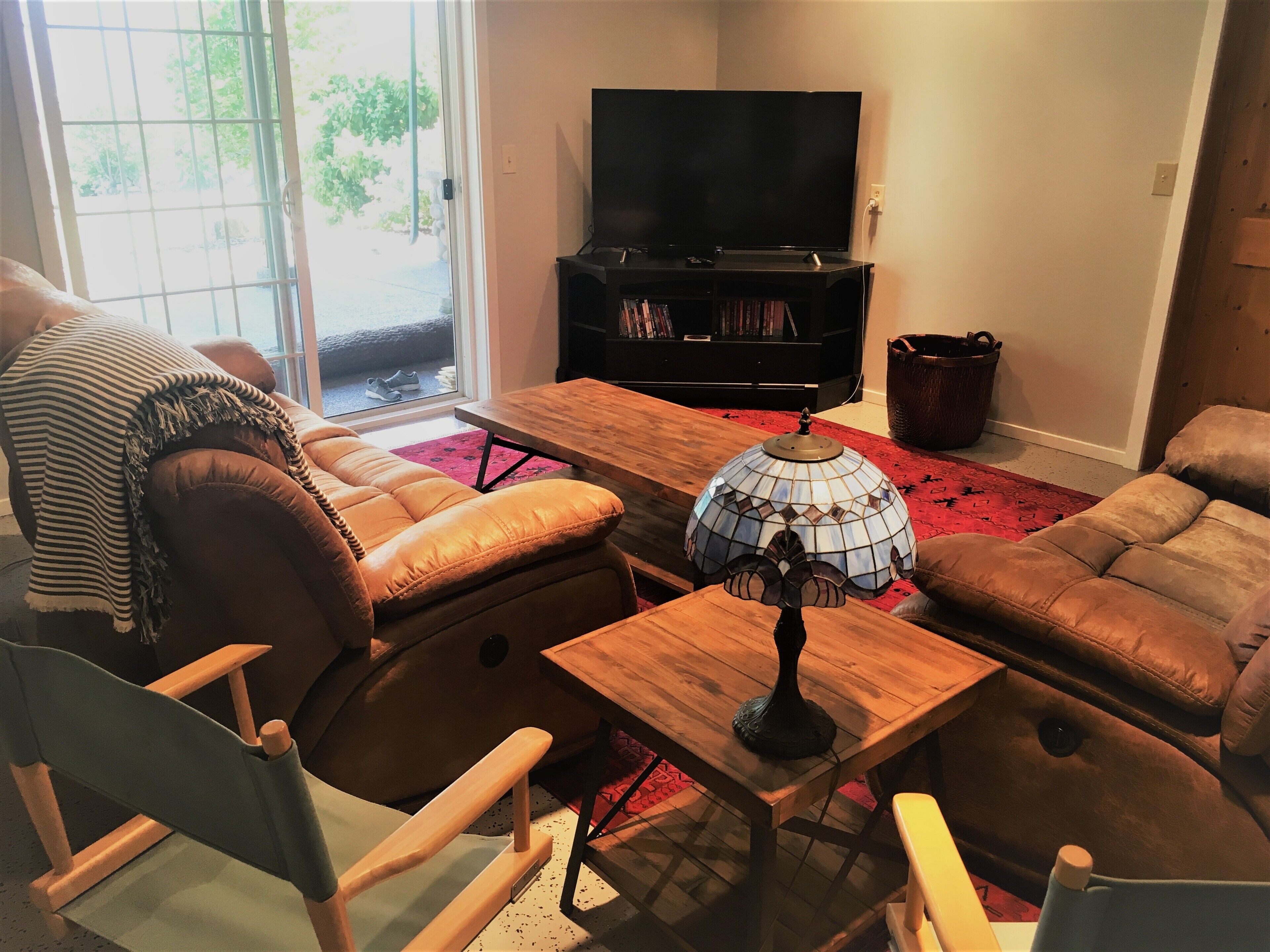 Ein Wohnzimmer mit einer Couch, einem Holztisch, einem Fernseher und einem Bücherregal.