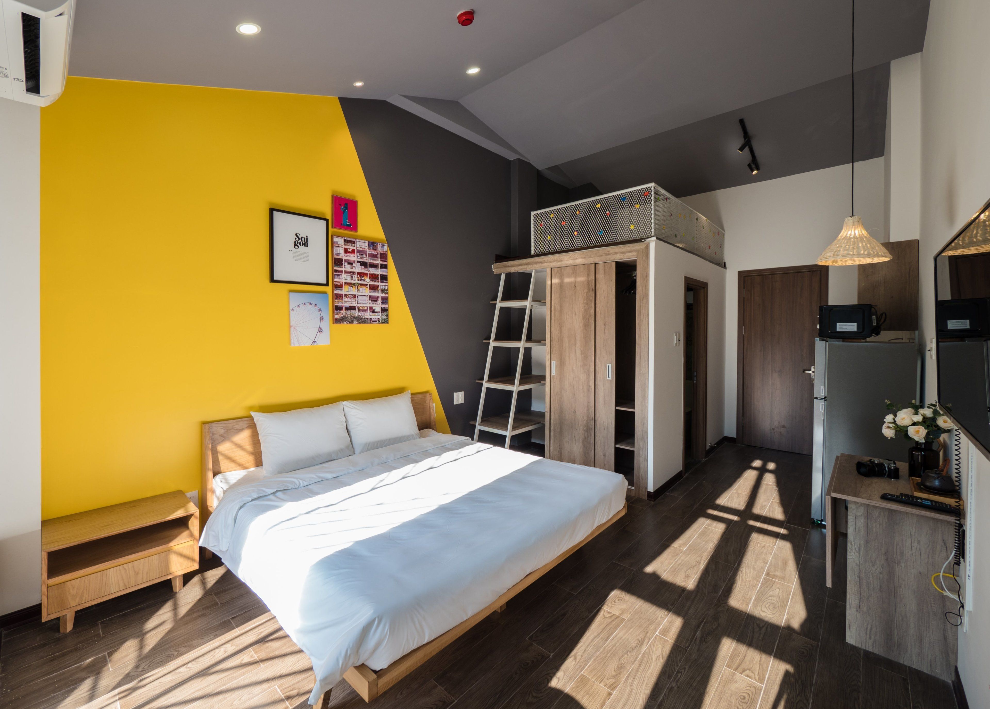A modern bedroom with a bed, a wardrobe, and a desk area.