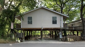 A two-story house with a wooden deck and a covered area.