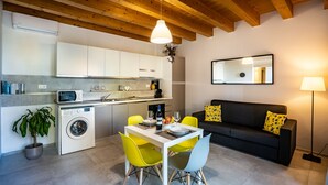 Um espaço compacto com cozinha, área de refeições e sofá.