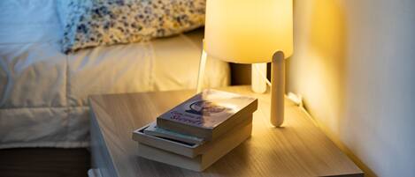 A bedside table with a lamp and a book.