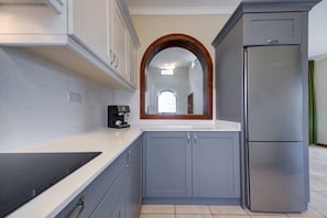 A compact kitchen with grey cabinets, a stainless steel refrigerator, and a coffee maker on the counter. - Villa Stephanotis~ Villa w/ Private Pool & Views (Il-Mellieħa)