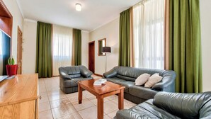 Una sala de estar con un sofá, una mesa de centro y un televisor.