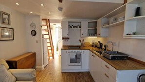 A compact kitchen with white cabinetry, a wooden countertop, and a built-in oven. - Steepfield Studio, bijou apartment Bantham S.Devon (Bantham, Kingsbridge)