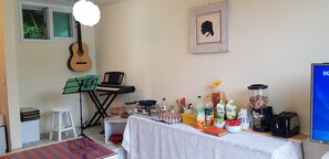 A room with a table set for breakfast, a guitar, a keyboard, and a framed picture on the wall. - I Pluss Poolviller Pension (Chuncheon)