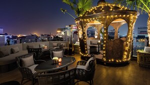 A rooftop lounge with a gazebo, seating areas, and a view of the city skyline. - La Sinfonía del Rey Hotel & Spa (Hanoi)