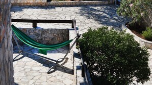 A stone patio with a hammock, a basketball court, and a view of the sea. - Villa Shanti | Pool, Beach & Basketball court (Rt Veslo)
