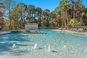 A swimming pool with clear water, surrounded by trees and a fenced area with lounge chairs. - "Salty Sun" - Golf Cart (included), Tennis, Pools, Golf, Beach... it's all here! (Destin)