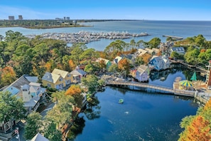 A marina with boats, waterfront houses, and a dock extending into the water.