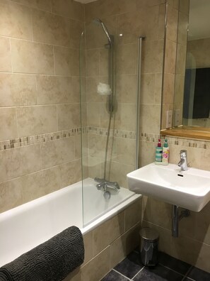 Een bad, een haardroger, handdoeken, shampoo
