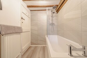 Un baño moderno con ducha, bañera y retrete.