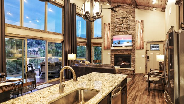 A spacious kitchen with a granite countertop, a built-in sink, and a stone fireplace.