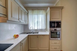 Una cocina con un lavamanos, un microondas Bosch y un horno.