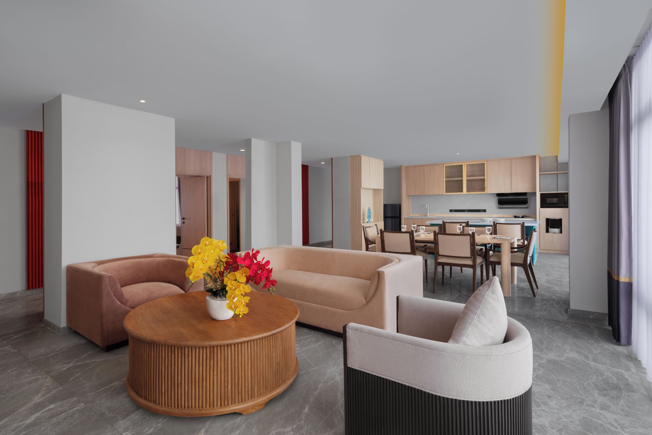 Un salon moderne avec un canapé, une table basse ronde et un coin repas comprenant des chaises et une table.