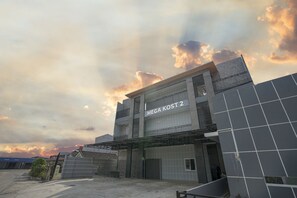 A building with a sign reading "MEGA KOST 2" and a covered entrance. - OYO 945 Mega Kost 2 (Palembang)