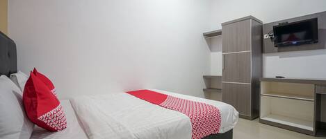 A modern bedroom with a bed, a TV mounted on the wall, and built-in storage units.