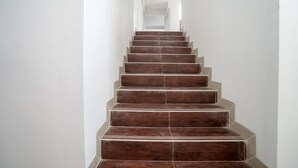 A staircase with wooden steps and white walls. - OYO 945 Mega Kost 2 (Palembang)