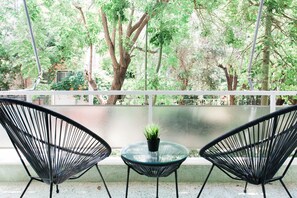 A balcony with two black wire mesh chairs and a small glass table with a potted plant. - Bright 2BD Apartment in Psychiko (Neo Psichiko)