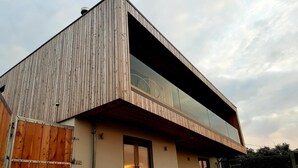 Un edificio moderno con techo inclinado y un amplio ventanal.