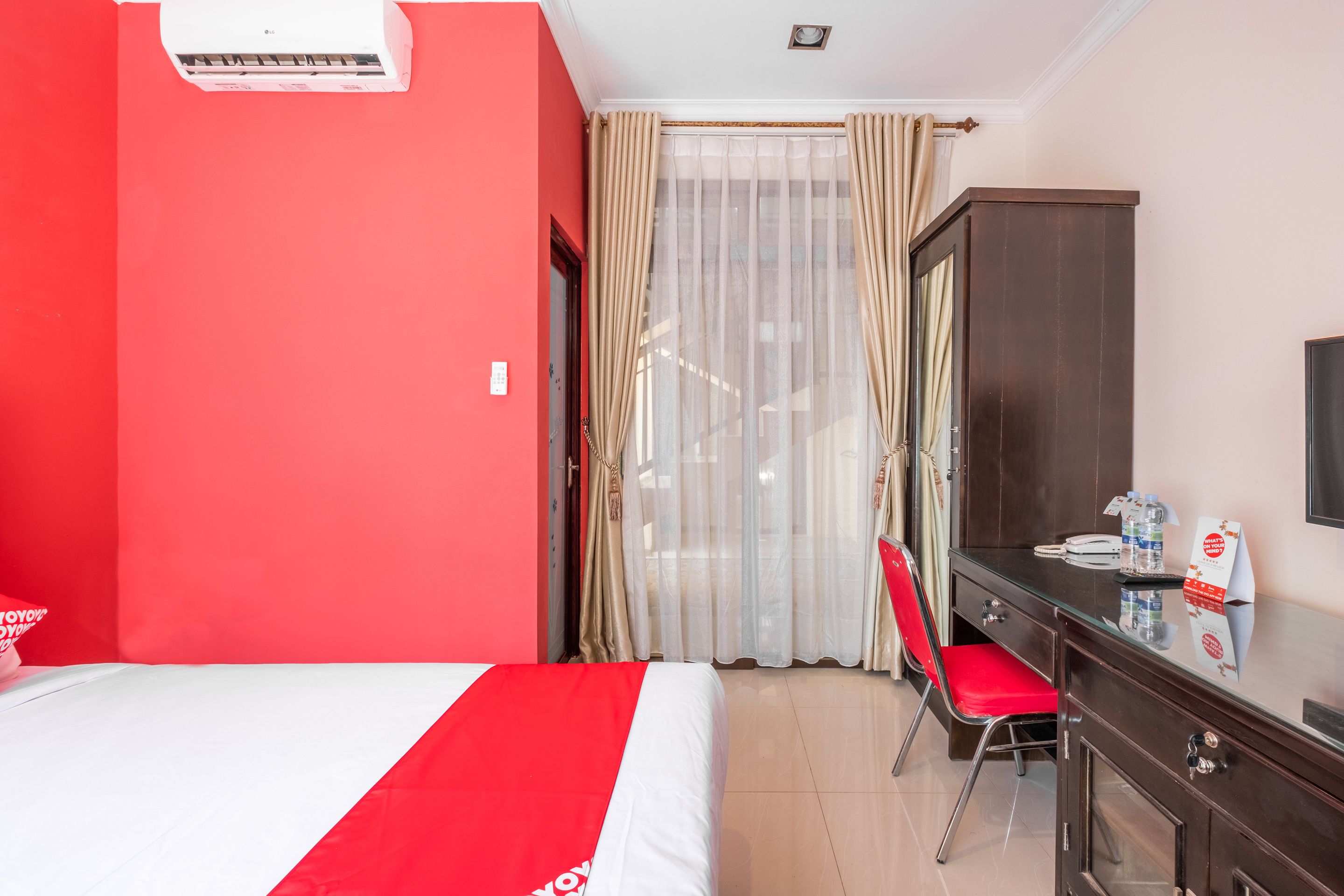 Una camera d'albergo con un letto, una scrivania, una sedia e un armadio.