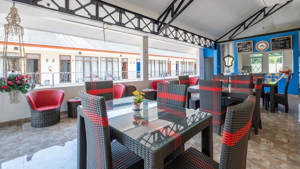 A restaurant with outdoor seating, wicker chairs, and a glass table. - OYO Collection O 1032 Rahayu Residence Syariah (West Cirebon)