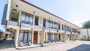 A multi-story hotel with balconies, outdoor seating, and a paved courtyard. - OYO Collection O 1032 Rahayu Residence Syariah (West Cirebon)