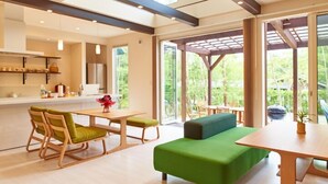 A modern kitchen with a dining area, large windows, and a wooden pergola. - Family Cottage NOTOIE (Shika)