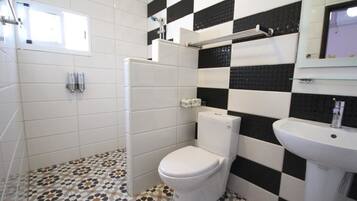 A bathroom with a toilet, sink, and tiled floor.