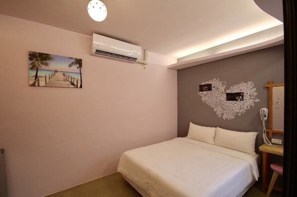 Un dormitorio con cama, una imagen de una playa, aire acondicionado y un adorno de pared.