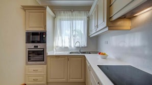 A kitchen with a Bosch oven, a sink, and a bowl of fruit on the counter.