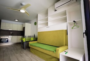 A compact living space with a kitchenette, a dining area, and a sofa. - D010 Seaside view Las Vistas TRG Tenerife Royal Gardens (Playa de la Américas)