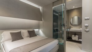 A modern bedroom with a large bed, a glass-enclosed shower, and a vanity with a mirror. - Fauno Urban Resort (Rome)