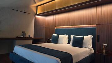 Una moderna camera d'albergo con un letto grande, un comodino e un tavolino.