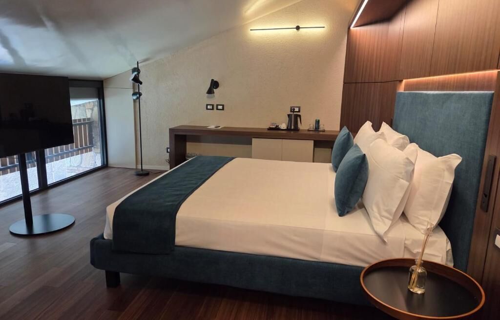 Habitación de hotel moderna con una cama grande, un escritorio y vistas al exterior.