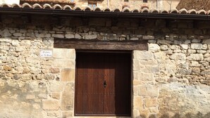 Un edificio de piedra con una puerta de madera y un letrero encima.