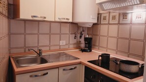 Une cuisine équipée d’un évier, d’une cuisinière et d’une machine à café.