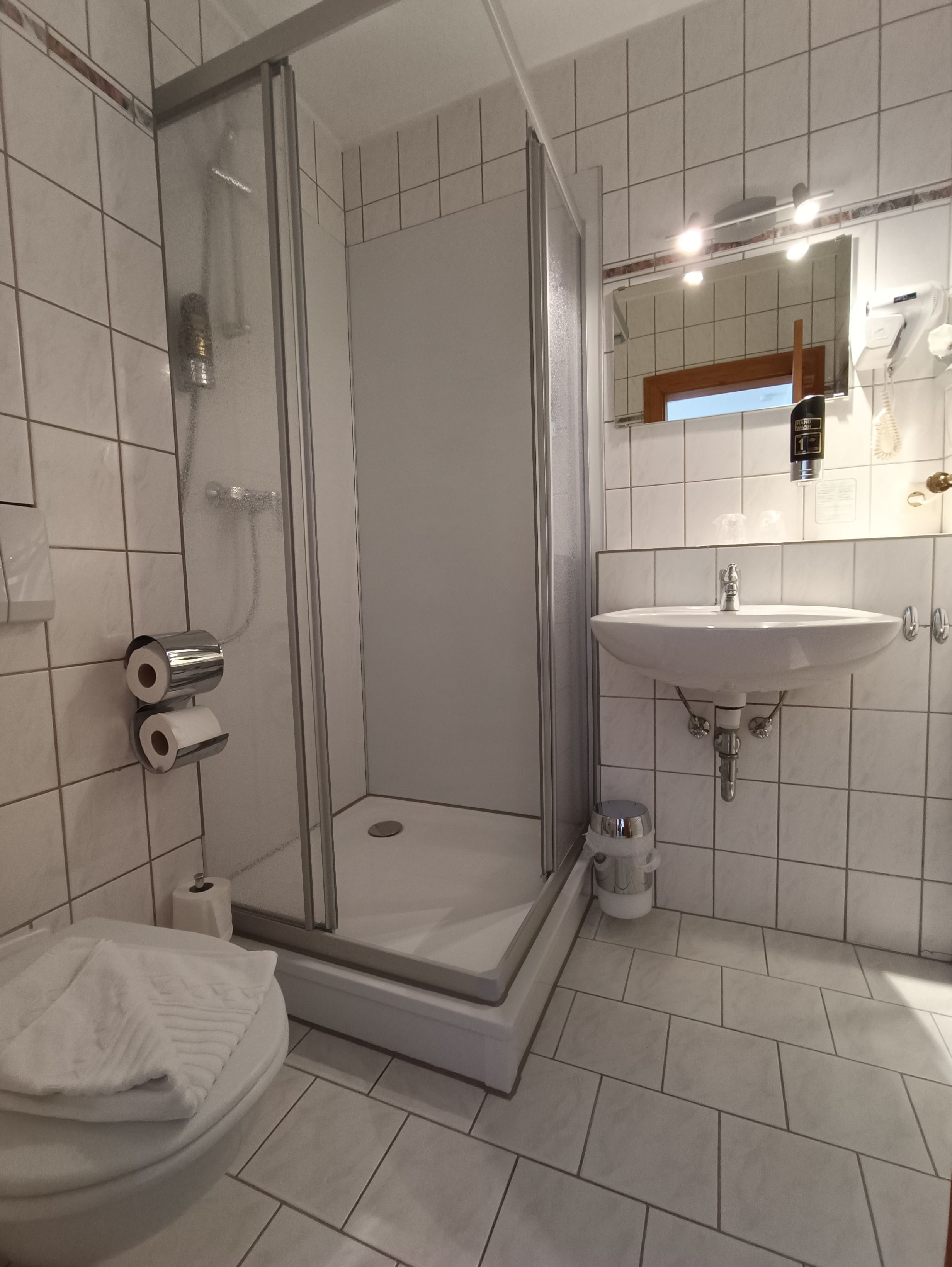 Une salle de bain moderne avec une douche à parois de verre, un lavabo et des toilettes.