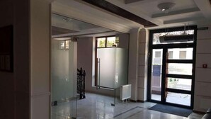 A modern hotel lobby with a glass partition, a radiator, and a door leading outside. - Apartment Osipova 40-9. (Odesa)