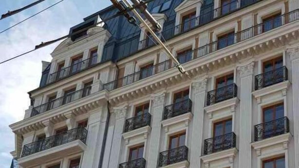 A multi-story building with a symmetrical facade, featuring evenly spaced windows and balconies with ornate metal railings. - Apartment Osipova 40-9. (Odesa)