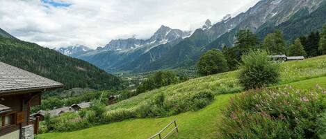 Paisaje montañoso con una casa y una valla de madera.