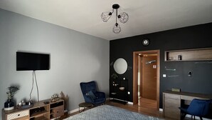 A bedroom with a large bed, a TV mounted on the wall, a desk, and a chair. - Villa 22 ,beautiful villa with a gorgeous view on Boka bay (Herceg Novi)