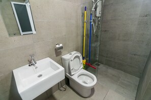 Et badeværelse med hvid vask, toilet og brusekabine i glas.