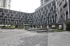 En moderne bygning med en markant facade præget af lodrette linjer og en gårdhave med en springvand.