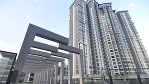 A modern high-rise building with a reflective glass facade and a geometric metal structure in the foreground. - Kenwingston Square Garden by IdealHub (Cyberjaya)