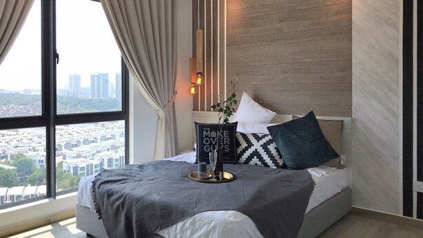 A modern bedroom with a large window, a bed with a grey and white duvet, a decorative pillow, and a bedside table with a vase and a glass. - Kenwingston Square Garden by IdealHub (Cyberjaya)